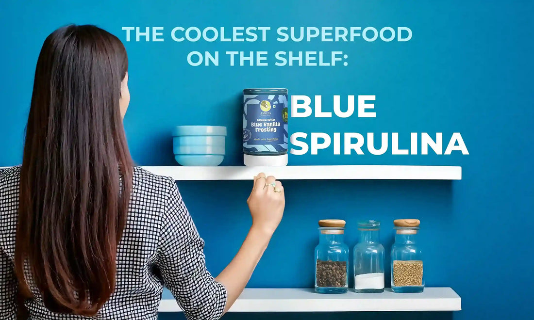 A woman reaches for AsmitA Organic Farms' Blue Vanilla Frosting Cashew Butter on a white shelf with the text “The Coolest Superfood on the Shelf: Blue Spirulina” in the background.