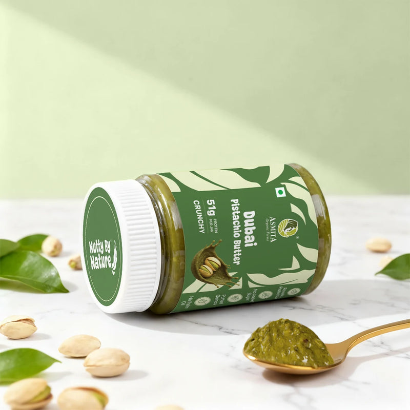 Jar of Dubai Pistachio Butter with a spoonful of butter on a light background