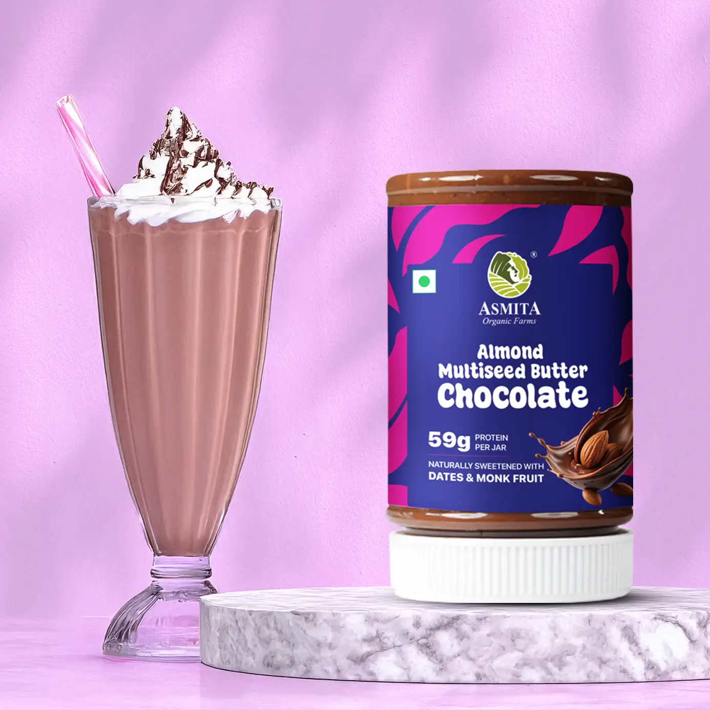 Almond multiseed butter chocolate product with a glass of chocolate shake on a pink background